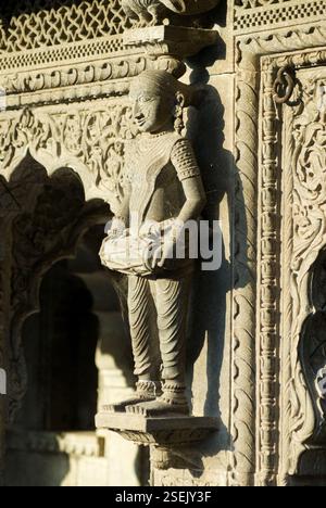 Donna ballerina che suona uno strumento di musica a tamburo scolpito in pietra sul muro del tempio di Maheshwar, Maheshwar, Madhya Pradesh, India, Asia Foto Stock