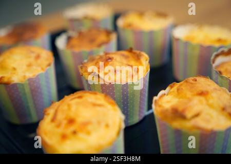 Un delizioso assortimento di cupcake è elegantemente seduto su un vassoio nero Foto Stock