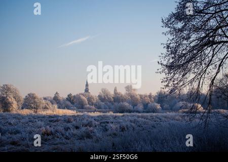 paesaggio ghiacciato con chiesa che si erge dalla città sullo sfondo Foto Stock