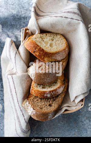 Vista dall'alto ravvicinata del pane a lievitazione naturale bianco e marrone appena tagliato in un cestino per il pane Foto Stock