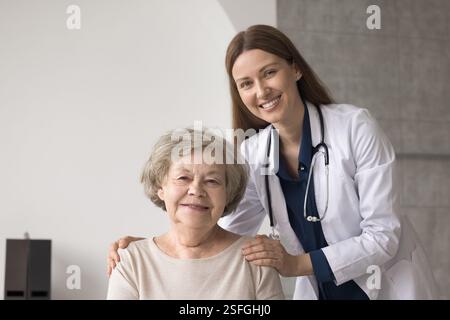 Ritratto felice paziente anziano e giovane donna sicura di sé medico Foto Stock