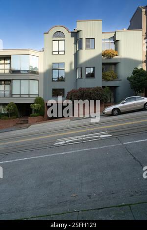 Auto su una strada ripida a San Francisco, vicino a Lombard Street. Gli edifici moderni si trovano lungo la ripida pendenza. Foto Stock