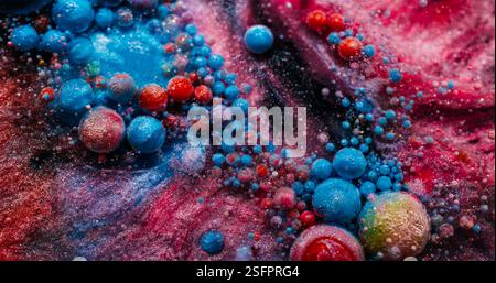 Flusso scintillante. Goccia di glitter di vernice. Colorato gel acrilico blu rosa che si dissolve in acqua in polvere scintillante. Miscela fluida consistenza astratta della schiuma di fondo. Foto Stock