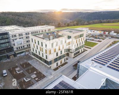 Moderno complesso di uffici con celle solari, situato in un paesaggio rurale al tramonto, nuova costruzione del Calw Health Campus, quartiere Calw, Black Fores Foto Stock