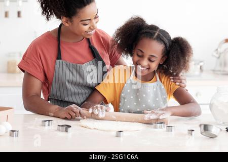Madre amorevole che aiuta la sua figlia teen con cottura Foto Stock