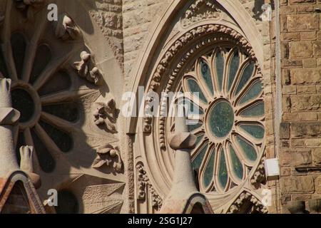 Vista ravvicinata dell'intricata architettura in pietra caratterizzata da una grande vetrata circolare e sculture decorative in pietra. Foto Stock