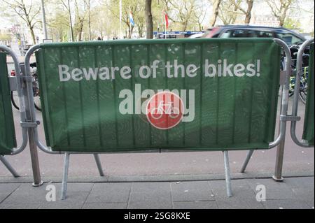 Un cartello verde con il simbolo di una bicicletta rossa ad Amsterdam avverte i ciclisti che stanno attraversando. Prestare attenzione ai ciclisti su strada. Questo è un avvertimento di sicurezza per la bicicletta Foto Stock