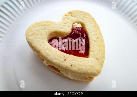 Cuore di pasta frolla ripieno di marmellata e panna Foto Stock