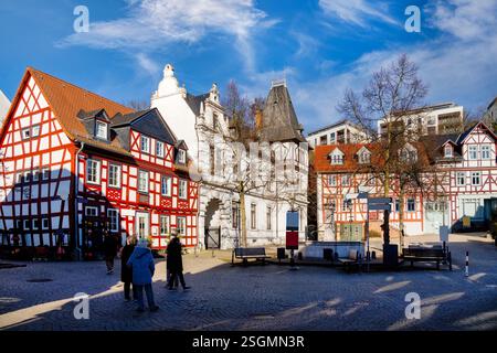 Persone che si godono una soleggiata giornata invernale nella storica piazza del mercato di idstein, in germania, circondata da case colorate a graticcio Foto Stock