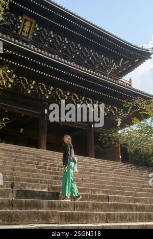 Donna che cammina su gradini di pietra verso un tempio tradizionale giapponese. Kyoto, Giappone Foto Stock