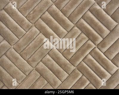 Primo piano di tessuto scamosciato marrone oro con motivo a tessitura a diamante. Simile alla tessitura in rattan. Tessuto scamosciato lucido in ottone dorato texture dello sfondo senza cuciture Foto Stock