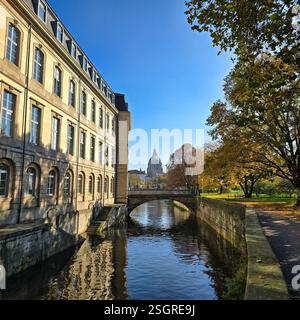 Una pittoresca scena autunnale caratterizzata da un canale, un ponte ed edifici storici sotto un cielo azzurro. Hannover, Germania Foto Stock