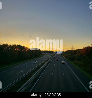 Uno splendido tramonto illumina l'autostrada in tonalità dorate, catturando l'essenza del viaggio serale e dell'avventura Hannover Langenhagen Foto Stock