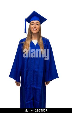 Giovane donna caucasica che indossa un camice blu e un mortarboard, sorride e celebra i risultati accademici su sfondo bianco, simboleggiando il nuovo Foto Stock