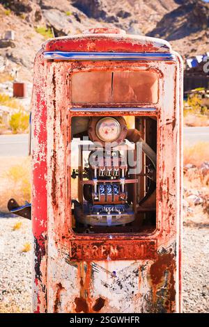 Distributore di benzina rosso e bianco con una finestra rotta. L'interno della stazione di rifornimento è arrugginito e sporco Foto Stock
