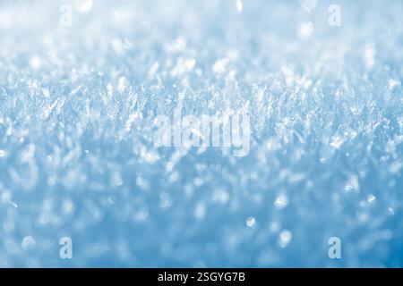 Vista ravvicinata di scintillanti cristalli di neve che formano una delicata scena invernale su uno sfondo blu sereno, catturando l'intricata bellezza a. Foto Stock