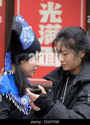 Londra, Regno Unito. Giovane donna cinese a Chinatown che indossa costumi tradizionali e copricapo Foto Stock