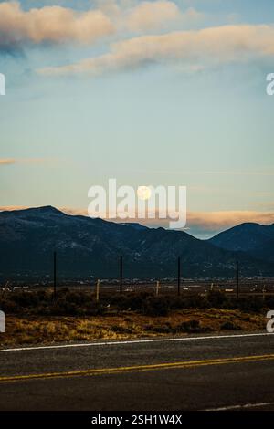 Luna piena sulla montagna coperta di neve Foto Stock