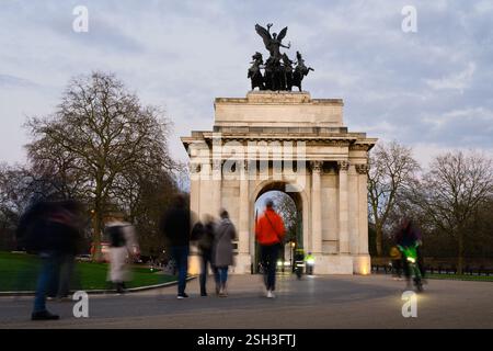 Londra, Regno Unito - 22 marzo 2024; ombre serali di persone che passano il Wellington Arch a Londra Foto Stock