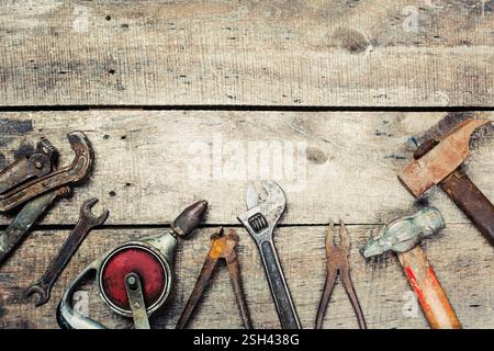 Utensili manuali disposti su una superficie rustica in legno che mostra varie forme e dimensioni per attività di miglioramento domestico Foto Stock