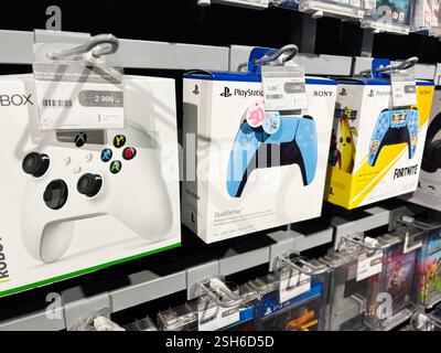 Kiev, Ucraina - 09 febbraio 2025: I controller delle console di gioco più popolari sono disposti in modo ordinato in un negozio al dettaglio Foto Stock