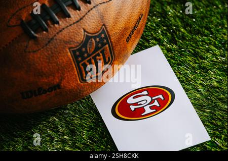 SAN FRANCISCO, USA, 10 FEBBRAIO 2025: Logo della squadra NFL dei San Francisco 49ers e pallone di football americano su Green Grass. Foto Stock