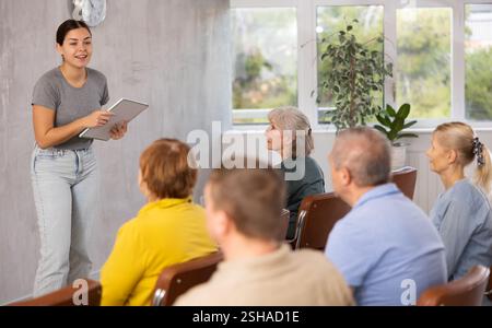 Giovane insegnante di sesso femminile che spiega il soggetto a studenti maturi Foto Stock