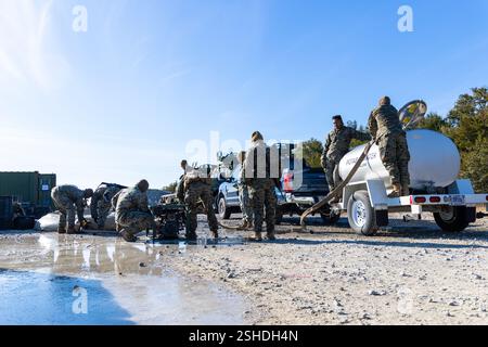 U.S. Marines con Combat Logistics Battalion 22, Combat Logistics Regiment 27, pompano acqua purificata in un rimorchio cisterna potabile durante un'esercitazione di assistenza umanitaria straniera come parte di un'esercitazione di addestramento sul campo della 26th Marine Expeditionary Unit, Marine Corps base Camp Lejeune, North Carolina, 15 gennaio 2025. La 26th Marine Expeditionary Unit condusse un'esercitazione di interoperabilità della Marine Air-Ground Task Force con elementi del 2nd Battalion, 2nd Marine Regiment come elemento di combattimento a terra, Combat Logistics Battalion 22, Combat Logistics Regiment 27 come elemento di combattimento logistico, e Mari Foto Stock