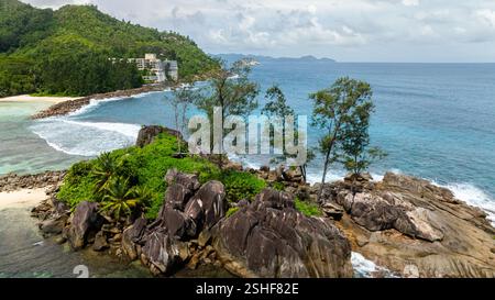 Spiagge sabbiose, acque cristalline e lussureggianti paesaggi tropicali. Seychelles, Mahe. Foto Stock