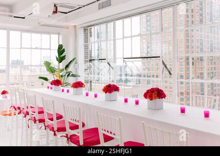Un elegante ambiente interno con fiori vivaci e candele, creando un'atmosfera accogliente per un evento imminente. Foto Stock