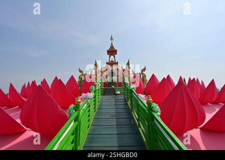 Accesso alla piattaforma galleggiante di loto rosso e al santuario del Buddha a Wat Saman Rattanaram a Chachoengsao, circondato da grandi petali di loto rosso Foto Stock