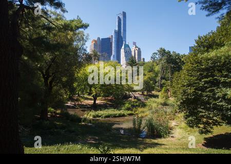 Il lago Pond a Central Park, One57, Trump parc e i grattacieli della 59th Street ovest, Midtown Manhattan, New York City Foto Stock