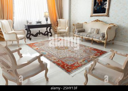 Elegante soggiorno con tappeto persiano lavorato a mano, elemento centrale del design classico degli interni. Foto Stock