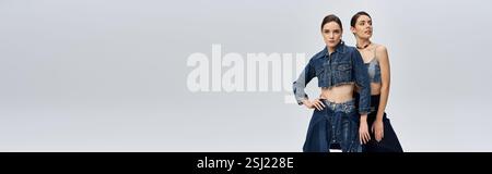 Le gemelle sono elegantemente arredate in denim alla moda, trasudando sicurezza e bellezza in un ambiente elegante. Foto Stock