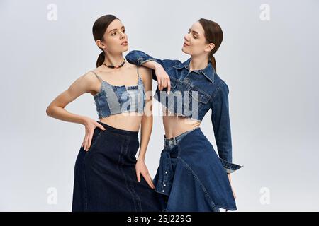 Le gemelle sfoggiano il loro stile unico in denim, sottolineando il loro splendido legame. Foto Stock