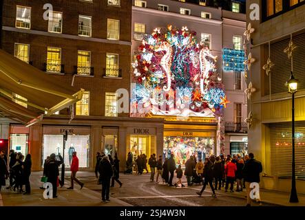 Una grande decorazione natalizia mostra sopra il negozio Dior in Old Bond Street, Mayfair, London W1 Foto Stock