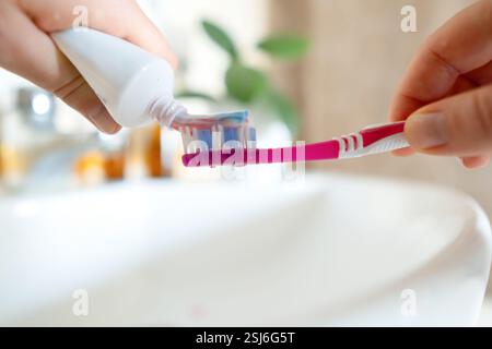 Donna sprema il dentifricio per spazzolarlo, utilizzando prodotti ecologici. Il dentifricio Safe assicura la cura orale senza ingredienti dannosi. Foto Stock