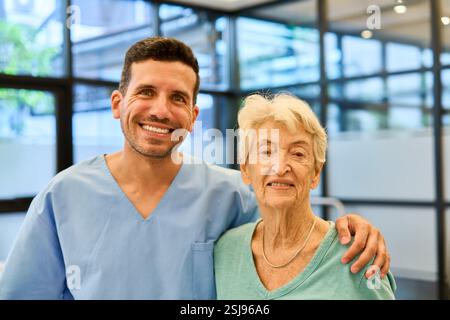 L'operatore sanitario amichevole accompagna le donne anziane nel centro di riabilitazione, rappresentando la cura e il sostegno degli anziani. Foto Stock