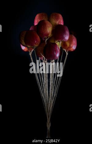 Bouquet surreale di mongolfiere di mele su sfondo scuro Foto Stock
