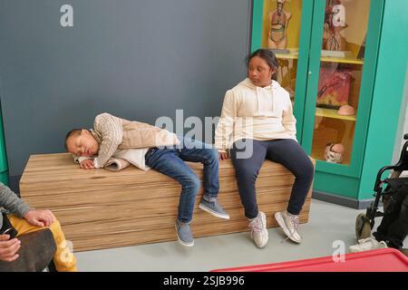 Ragazzo stanco che dorme sulla panchina accanto alla ragazza nel centro scientifico Foto Stock