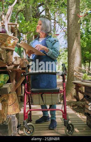 Donna disabile che lavora al mercato agricolo Foto Stock