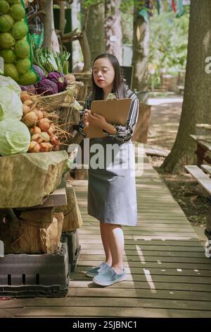 Donna disabile che lavora al mercato agricolo Foto Stock