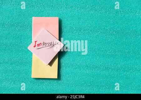 "Impossible" riscritto come "i'm possible" su una nota adesiva, che rappresenta la fiducia e la definizione degli obiettivi. Foto Stock