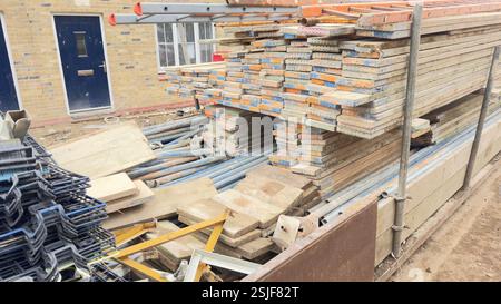 Detriti e materiali da cantiere, tra cui tavole per impalcature impilate, tubi per impalcature in metallo e altre tavole e attrezzature in legno, tutto questo Foto Stock