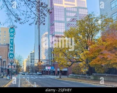 Una scena di strada a Portland, Oregon, con un'importante insegna verde che recita "PORTLAND" in stile retrò, e fiancheggiata da uno skyline moderno e da alberi autunnali. Foto Stock