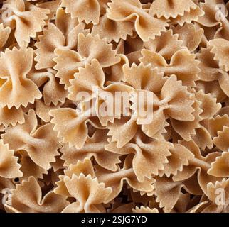 Vista ravvicinata della farfalle di grano intero crudo che forma un appetitoso sfondo Foto Stock