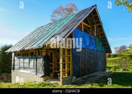 Piccola struttura in legno struttura residenziale telaio su fondamenta in calcestruzzo nel processo di costruzione in ambiente rurale Foto Stock