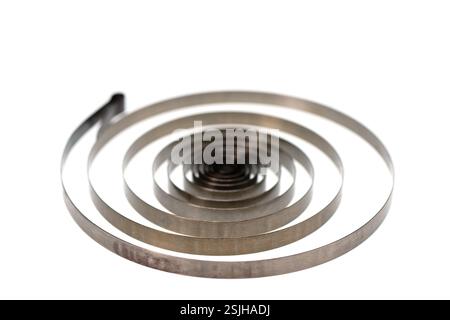 Molla a spirale in metallo isolata su sfondo bianco, messa a fuoco selettiva Foto Stock