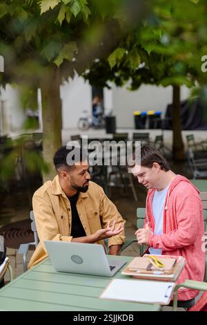 Giovane con sindrome di Down studyng con insegnante speciale educatore. Foto Stock