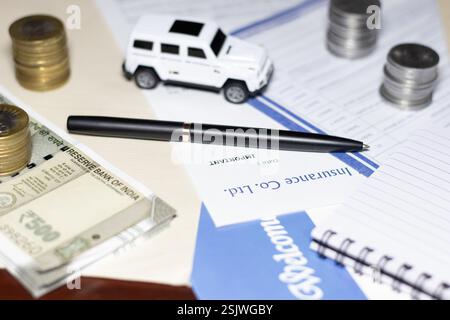 Concetto di assicurazione di viaggio con valuta, moneta, auto giocattolo con blocco note e penna Foto Stock